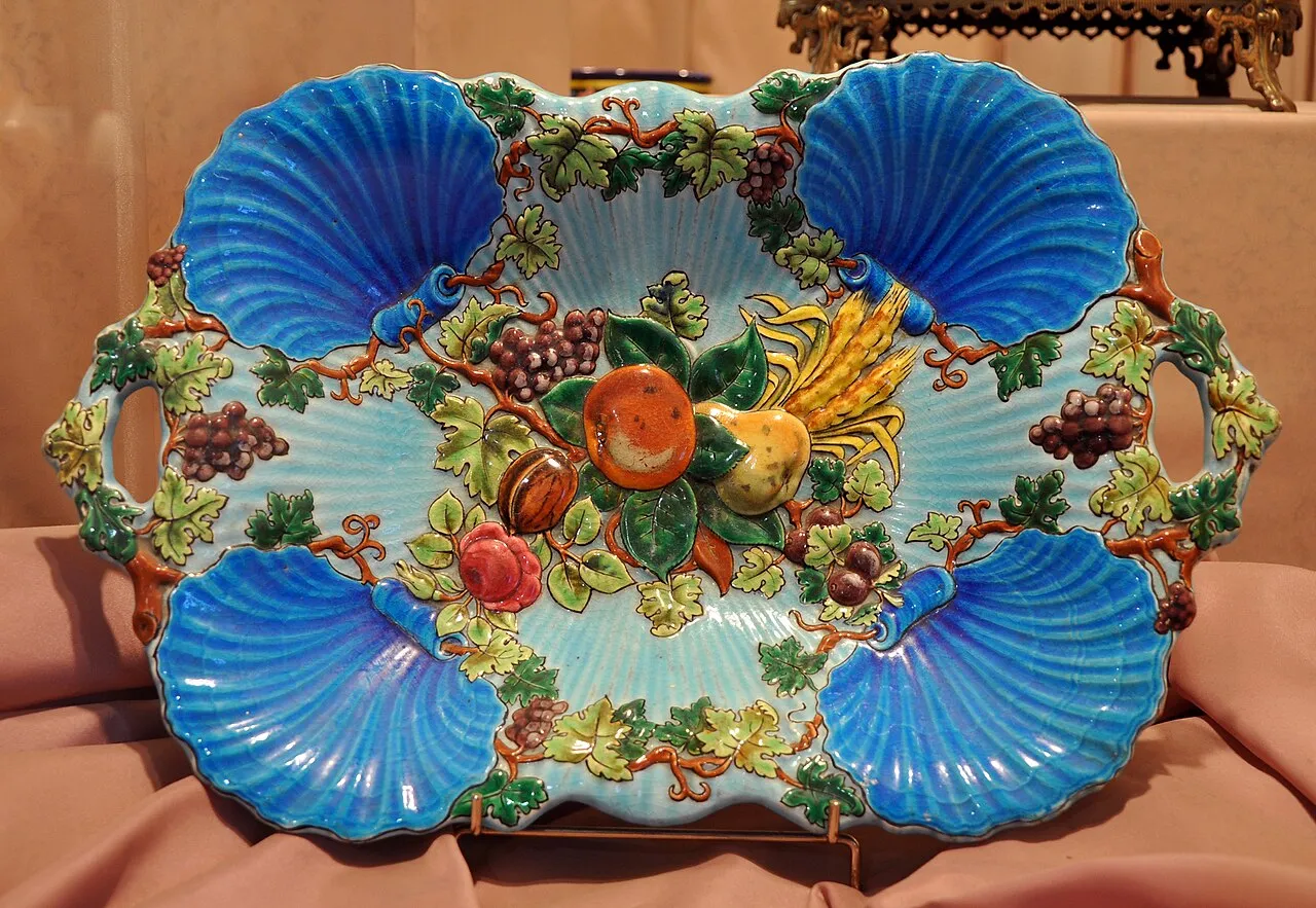 Plateau à anses en faïence émaillée, avec quatre coquilles bleu turquoise et, en relief, des fruits, des pampres et des épis de blé