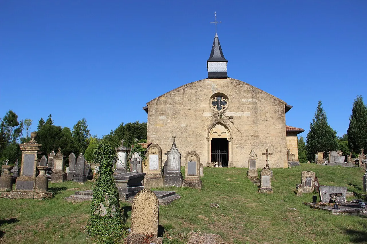 La chapelle Saint-Hilaire de Marville, façade à rosace et petit clocher, au milieu des tombes anciennes du cimetière